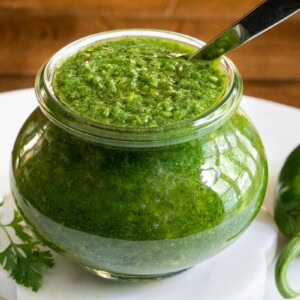 Horizontal photo of a jar of Zhoug Sauce.
