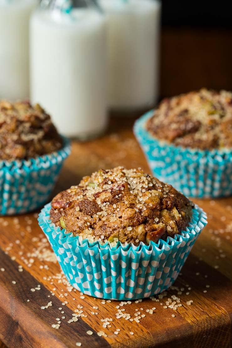 Vertical close up photo of Zucchini Morning Glory Muffins in turquoise muffin liners.