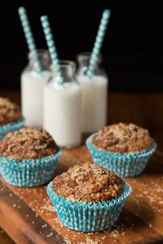 Vertical picture of zucchini morning glory muffins on a wooden cutting board