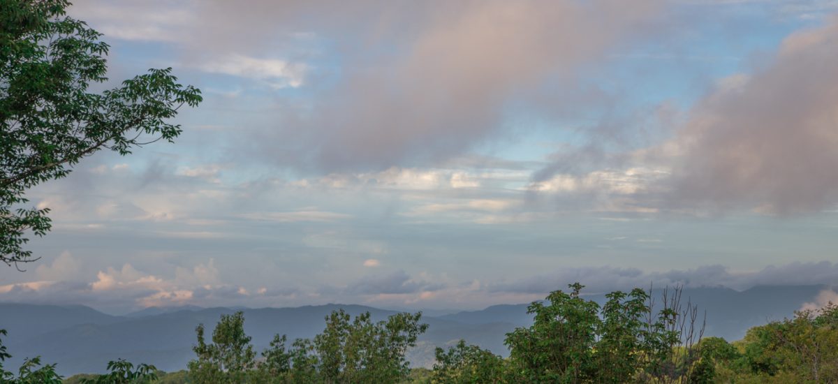 North Carolina Mountains - Summer 2016 - thecafesucrefarine.com Panoramic shot of the North Carolina Mountains with green trees and a colorful, stormy sky.