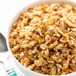 Vertical photo of a white bowl filled with Best Ever Granola.