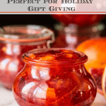 Vertical closeup photo of jars of Easy Blood Orange Marmalade on a marble surface.