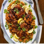 Overhead vertical photo of a serving platter of Charred Honey Lemon Chicken with Crispy Chickpeas.